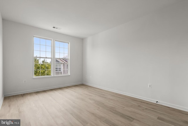 spare room featuring light wood finished floors and baseboards