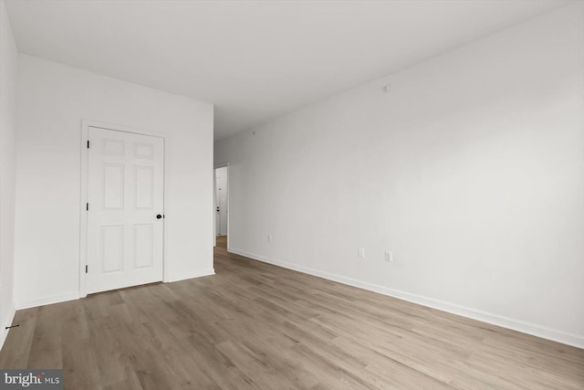 spare room featuring wood finished floors and baseboards