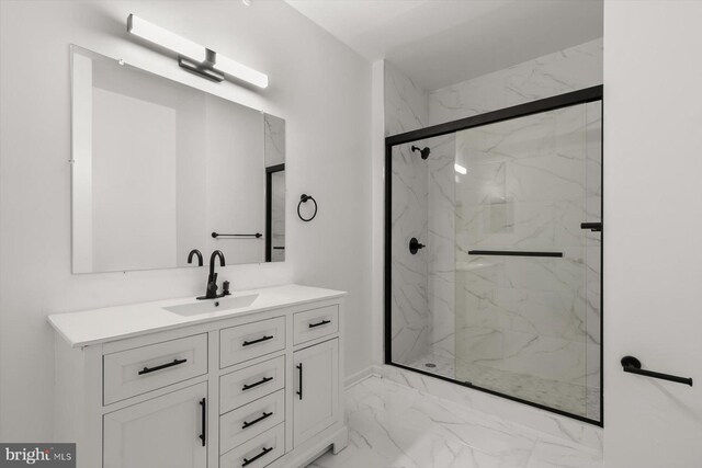 bathroom with marble finish floors, a marble finish shower, and vanity