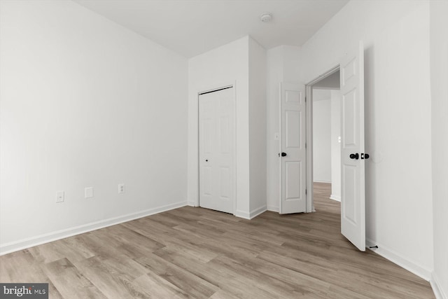 unfurnished bedroom featuring light wood-style flooring and baseboards