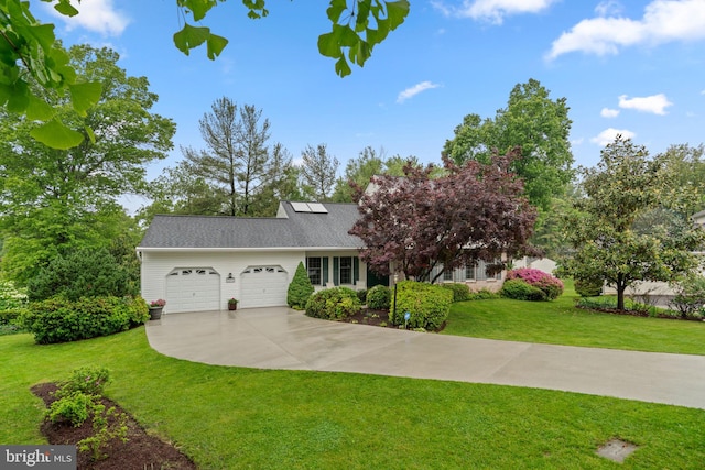 view of front of home featuring an attached garage, a front lawn, and driveway