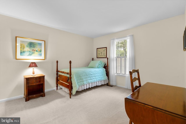 bedroom with light carpet and baseboards