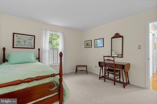 bedroom featuring light colored carpet and baseboards