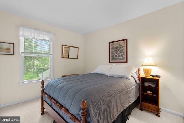 bedroom featuring light colored carpet, multiple windows, and baseboards