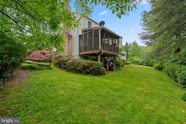 back of house with a sunroom and a lawn