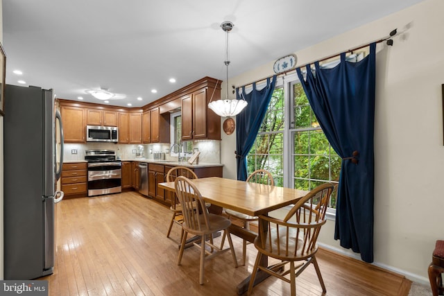 dining room with light wood-style floors, baseboards, and recessed lighting