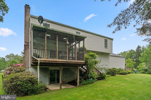 rear view of property featuring a sunroom, a yard, stairs, a chimney, and a patio