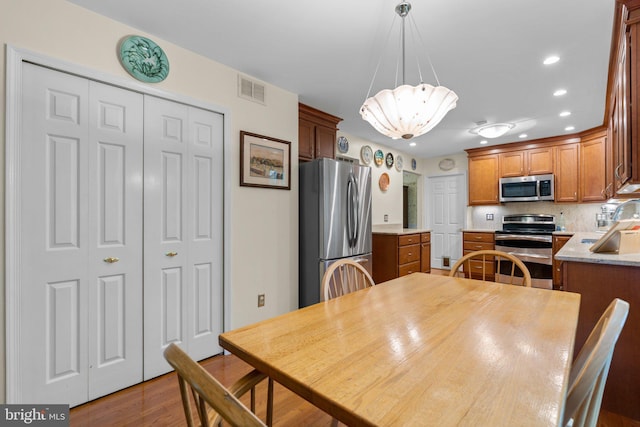 dining room featuring a chandelier, recessed lighting, and wood finished floors