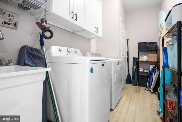 309 N Glebe Rd, Montross, VA 22520 - laundry room with cabinet space, washer and clothes dryer, and light wood-type flooring