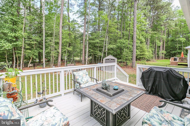 309 N Glebe Rd, Montross, VA 22520 - deck featuring outdoor dining space, an outdoor structure, a grill, a shed, and a view of trees