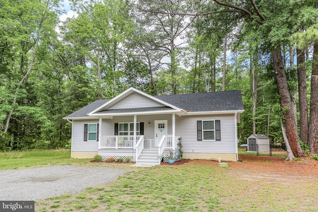 309 N Glebe Rd, Montross, VA 22520 - view of front of house with a porch, a shed, an outdoor structure, roof with shingles, and a front yard