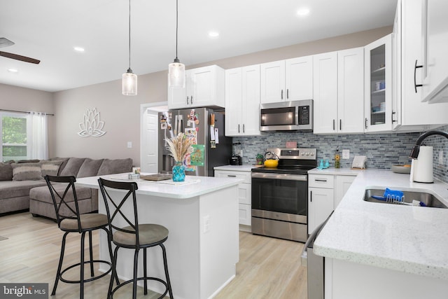309 N Glebe Rd, Montross, VA 22520 - kitchen with stainless steel appliances, open floor plan, a sink, a breakfast bar area, and backsplash
