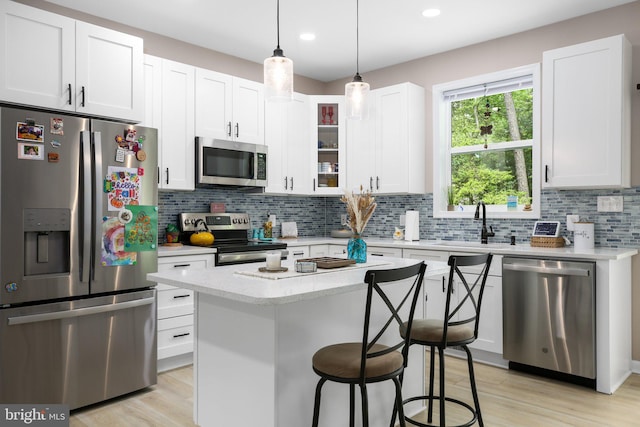 309 N Glebe Rd, Montross, VA 22520 - kitchen featuring stainless steel appliances, a sink, a kitchen breakfast bar, tasteful backsplash, and white cabinetry