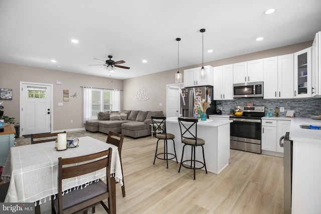 309 N Glebe Rd, Montross, VA 22520 - kitchen featuring appliances with stainless steel finishes, a center island, a kitchen breakfast bar, light wood-style flooring, and recessed lighting