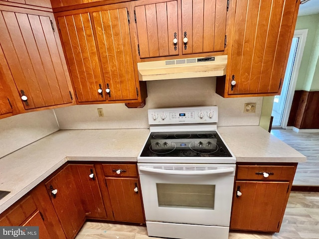 203 N Cedar St, Lititz, PA 17543 - kitchen with white electric stove, under cabinet range hood, light countertops, and brown cabinets