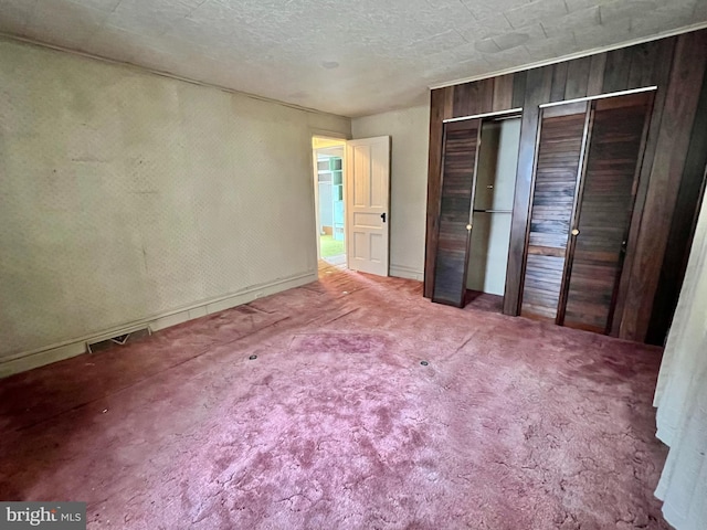 203 N Cedar St, Lititz, PA 17543 - unfurnished bedroom featuring multiple closets, carpet, wooden walls, and baseboards