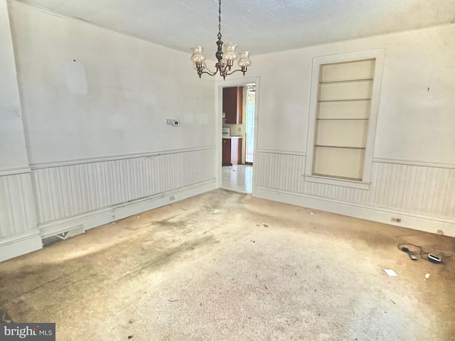 203 N Cedar St, Lititz, PA 17543 - spare room featuring carpet, a chandelier, built in features, and wainscoting