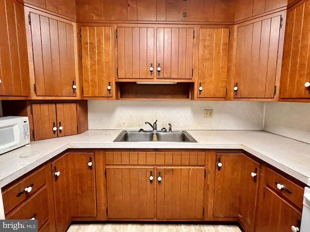 203 N Cedar St, Lititz, PA 17543 - kitchen featuring a sink, white microwave, light countertops, and brown cabinets