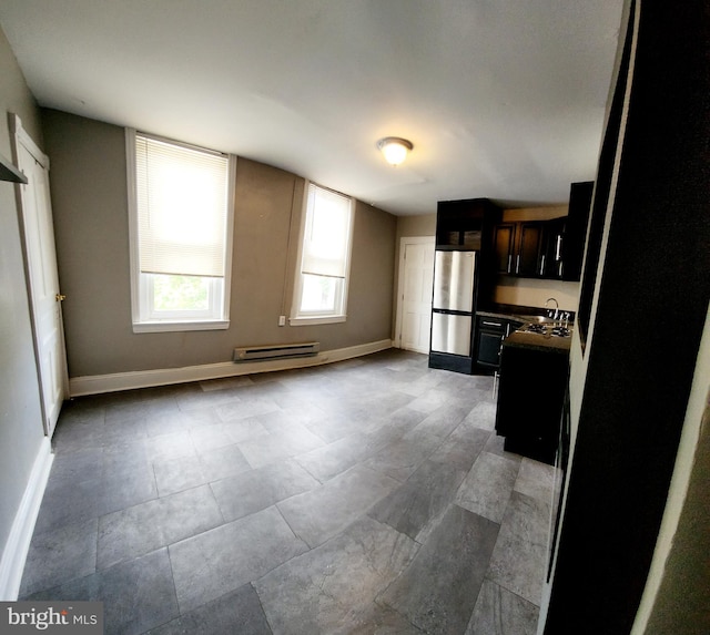2067 W Stella St, Philadelphia, PA 19132 - kitchen featuring freestanding refrigerator, baseboards, a sink, and dark countertops