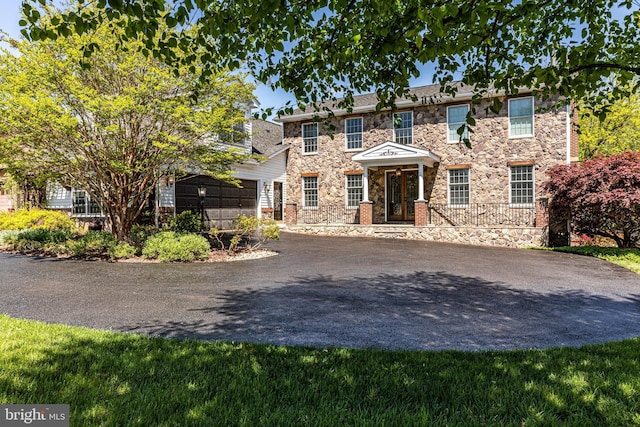 7140 Poole Jones Rd, Frederick, MD 21702 - view of front facade with asphalt driveway, stone siding, an attached garage, and french doors