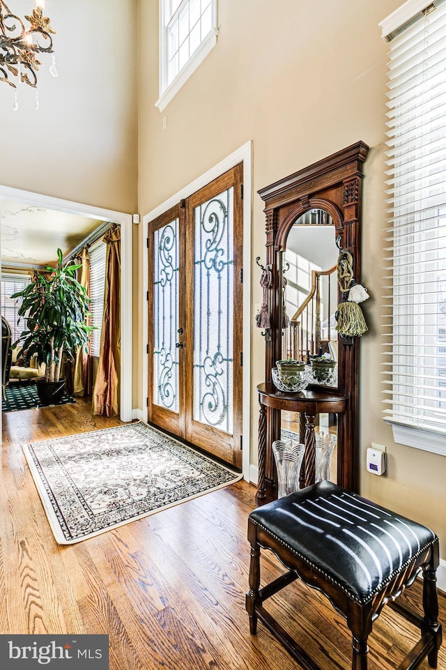 7140 Poole Jones Rd, Frederick, MD 21702 - foyer entrance featuring french doors, wood finished floors, plenty of natural light, and a towering ceiling