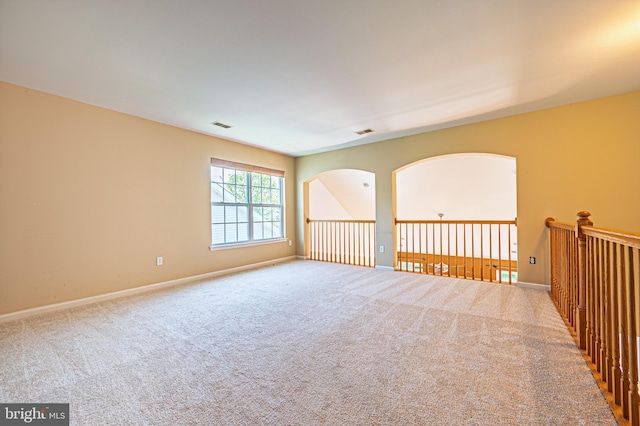 carpeted empty room featuring baseboards