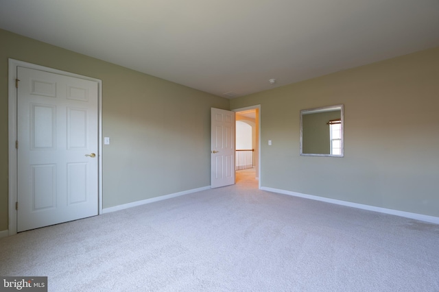 spare room featuring carpet and baseboards