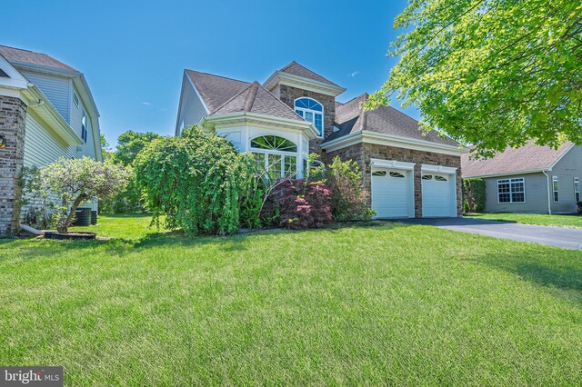 view of front of property with asphalt driveway, stone siding, an attached garage, and a front lawn