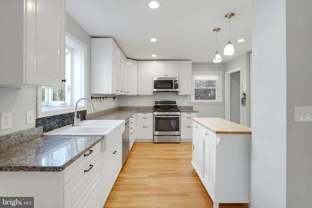 1305 S Buchanan St S, Arlington, VA 22204 - kitchen with appliances with stainless steel finishes, healthy amount of natural light, white cabinets, light wood finished floors, and recessed lighting