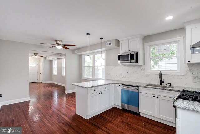3411 Roselawn Ave, Baltimore, MD 21214 - kitchen featuring stainless steel appliances, a sink, a peninsula, light stone countertops, and white cabinetry