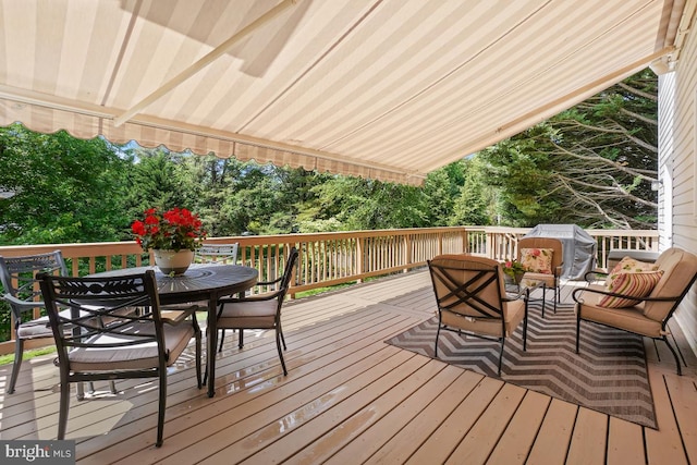 wooden deck featuring outdoor dining space, a grill, and an outdoor living space