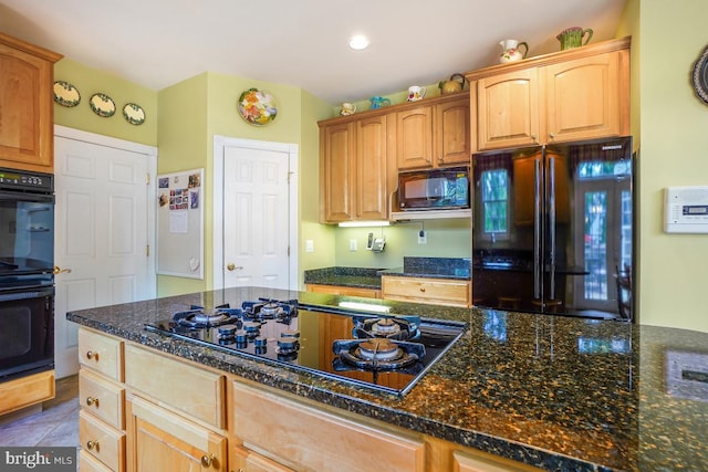 kitchen featuring black appliances and dark stone countertops