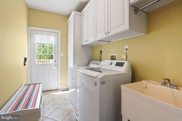 clothes washing area with separate washer and dryer, cabinet space, and light tile patterned floors