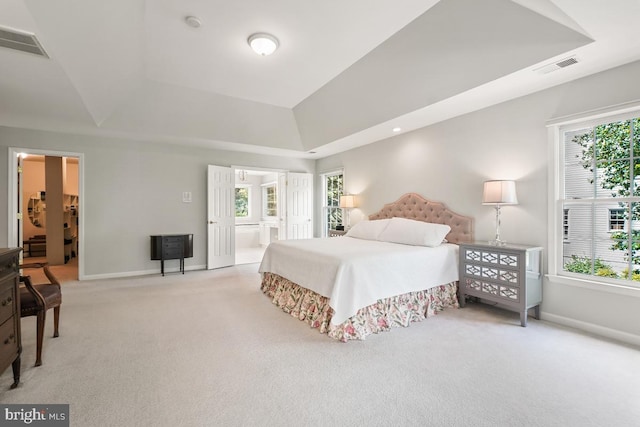 carpeted bedroom with multiple windows, baseboards, and ensuite bathroom