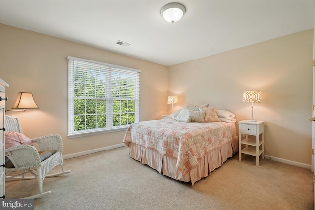 bedroom with baseboards and light colored carpet