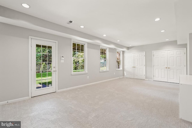 unfurnished bedroom featuring recessed lighting, multiple closets, multiple windows, access to outside, and carpet