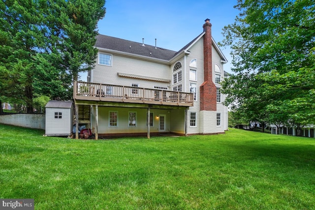 rear view of house featuring a deck, a storage shed, a lawn, an outbuilding, and a chimney