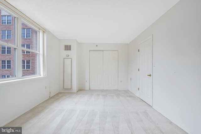 900 N Taylor St Unit 1105, Arlington, VA 22203 - unfurnished bedroom with multiple windows, light colored carpet, and a closet