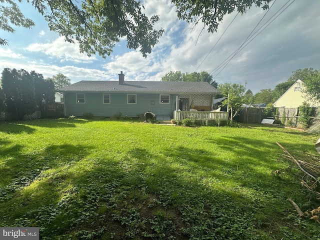 back of house with a wooden deck and a chimney