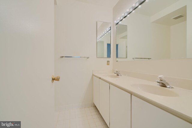 1 Brooking Ct Unit 202, Lutherville Timonium, MD 21093 - bathroom with tile patterned floors, double vanity, and baseboards