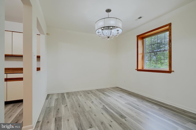 1 Brooking Ct Unit 202, Lutherville Timonium, MD 21093 - spare room featuring light wood-style flooring, a chandelier, and baseboards