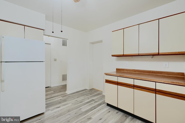 1 Brooking Ct Unit 202, Lutherville Timonium, MD 21093 - kitchen with freestanding refrigerator, light wood-style floors, white cabinetry, light countertops, and baseboards