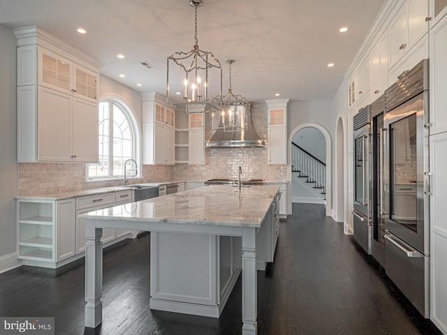 1337 Carolannes Way Unit B6, West Chester, PA 19382 - kitchen featuring open shelves, wall chimney exhaust hood, a kitchen island with sink, a chandelier, and recessed lighting