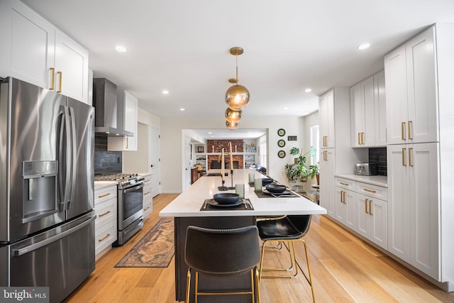 36 Gettysburg Ln, Newtown, PA 18940 - kitchen with stainless steel appliances, wall chimney exhaust hood, light countertops, light wood-type flooring, and tasteful backsplash