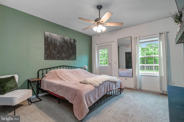 carpeted bedroom with multiple windows, ceiling fan, and baseboards