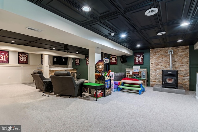 game room with carpet floors, a wood stove, an ornate ceiling, a decorative wall, and bar area