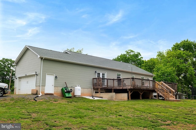 back of property featuring a wooden deck, a yard, an attached garage, stairs, and driveway