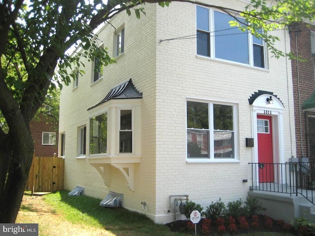 view of home's exterior with brick siding and fence