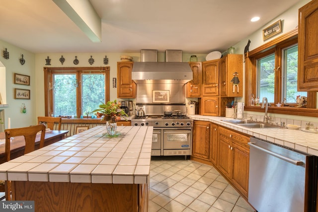 3012 Duncan Rd, White Hall, MD 21161 - kitchen with stainless steel appliances, tile counters, a sink, wall chimney range hood, and light tile patterned floors