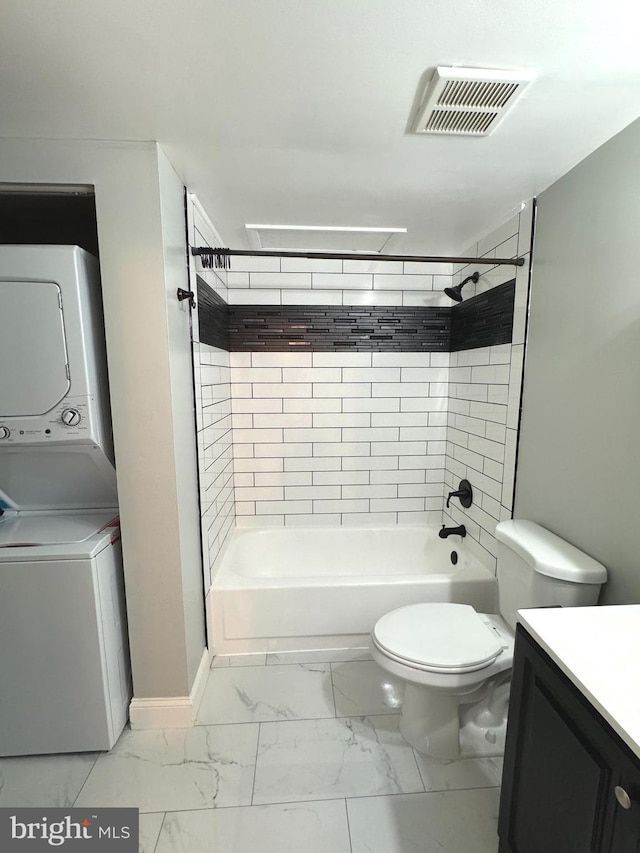 full bath with stacked washer / drying machine, marble finish flooring, vanity, toilet, and bathtub / shower combination